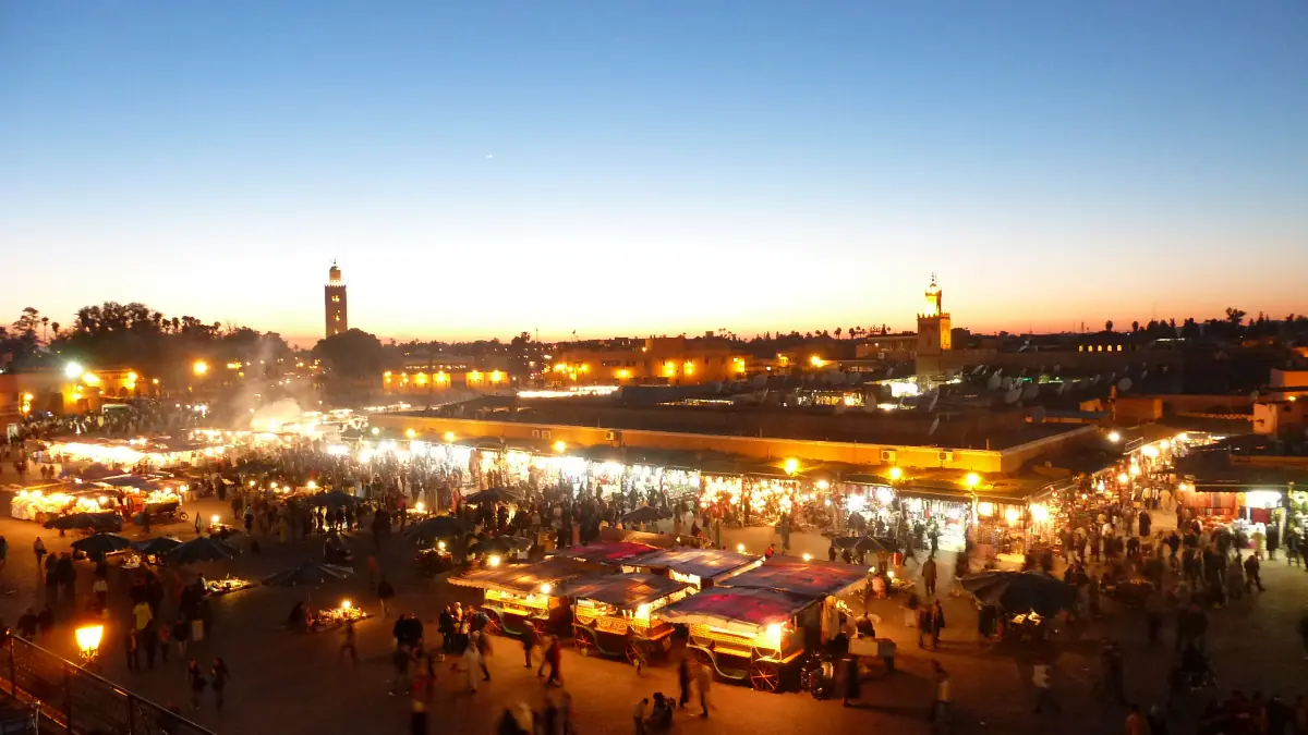 Jemaa el-Fna at dusk with the food stalls and the Koutoubia minaret